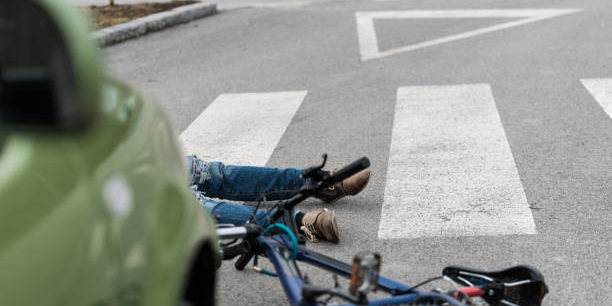 Traffic accident.Young man on bike hit by a car